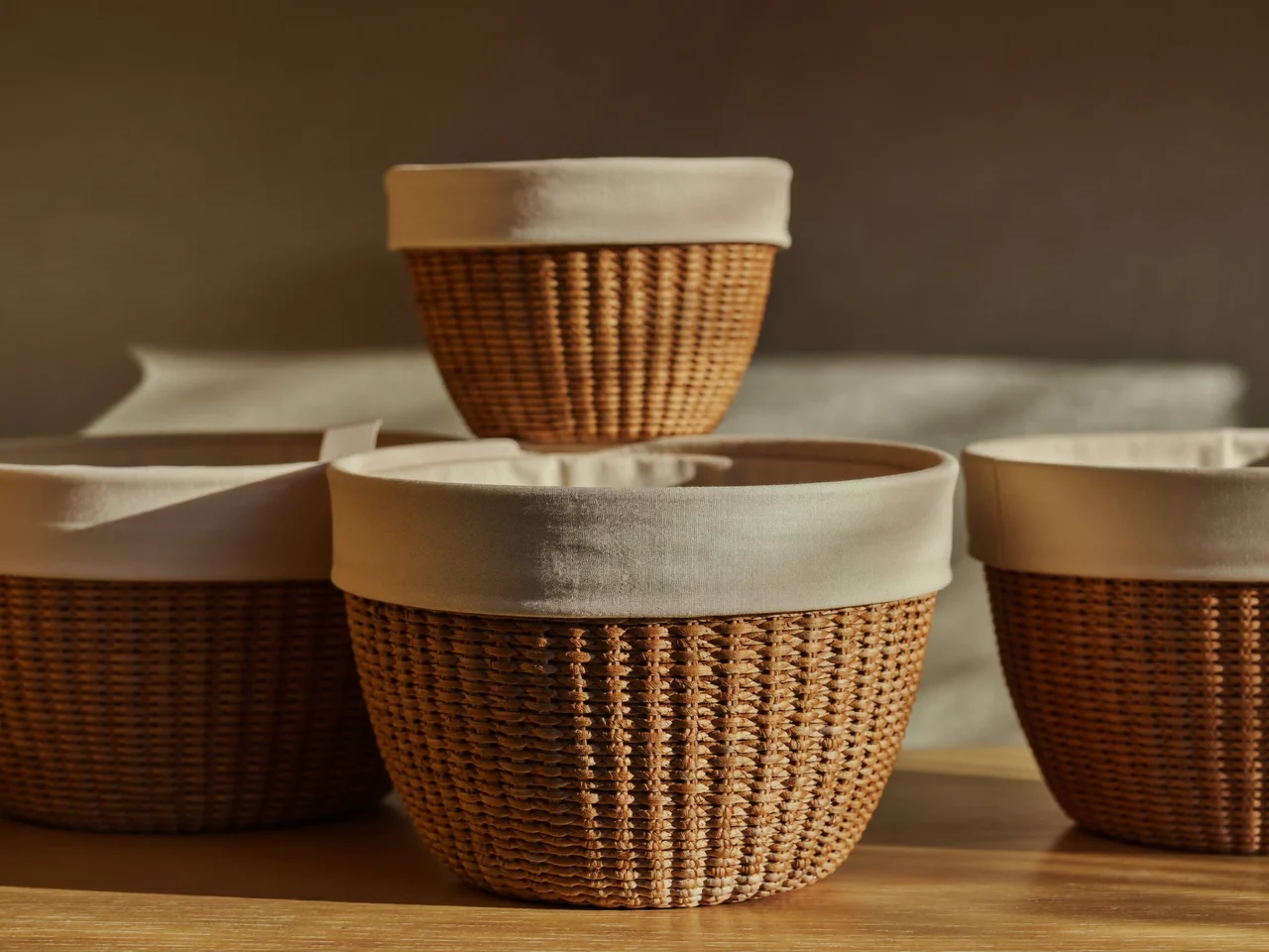 Trois paniers tressés en jonc de mer doublés de tissu sur une étagère